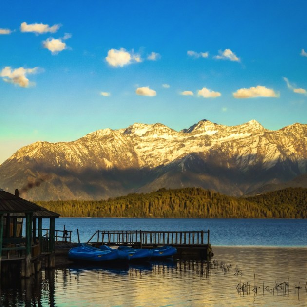 a lake with a dock and mountains in the background