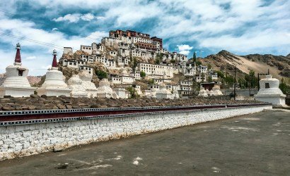 white and brown concrete building near body of water under blue sky during daytime
